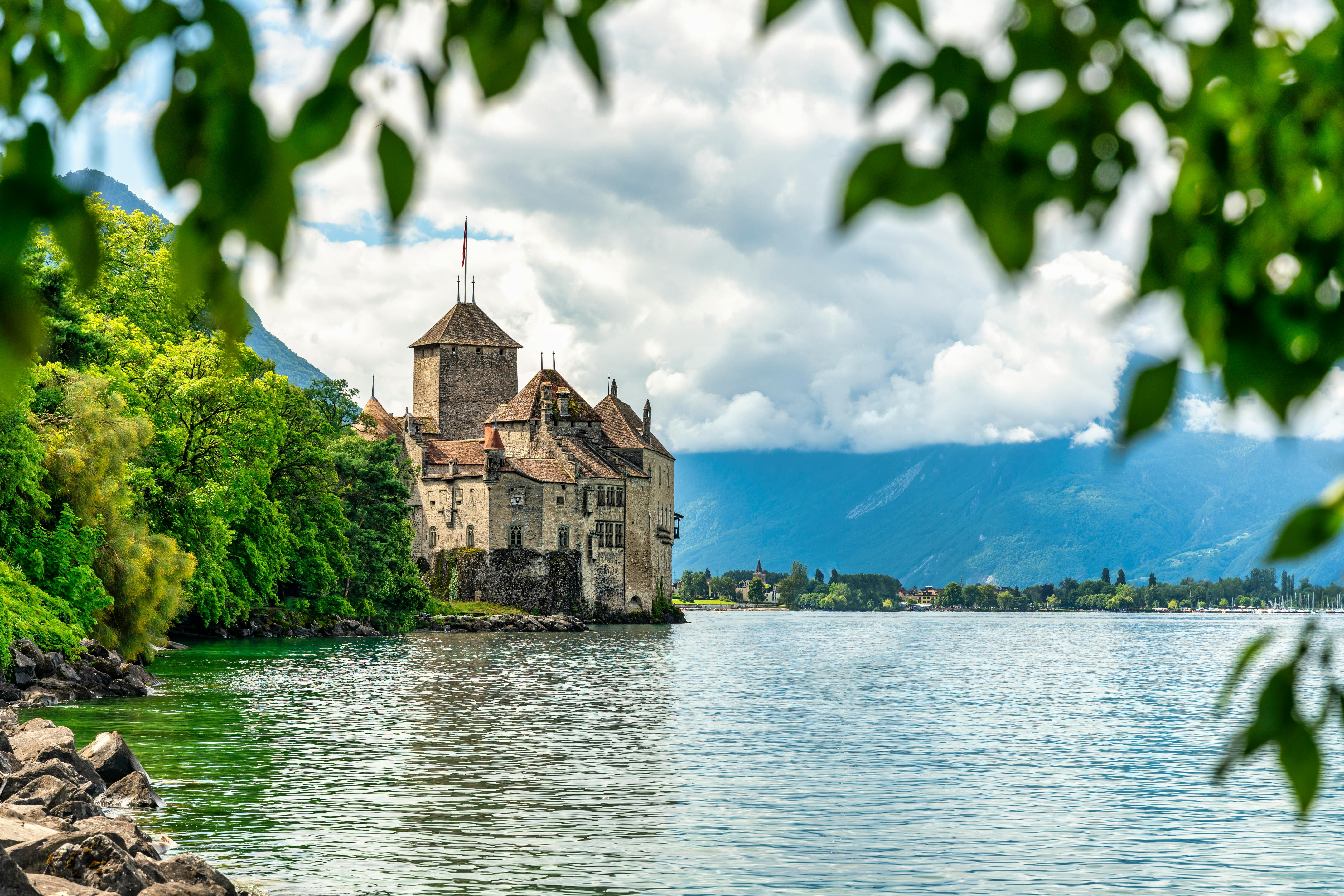 A Swiss castle by the lake on a clear day with blue sky